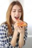depositphotos_111248548-stock-photo-happy-young-woman-eating-pizza.jpg
